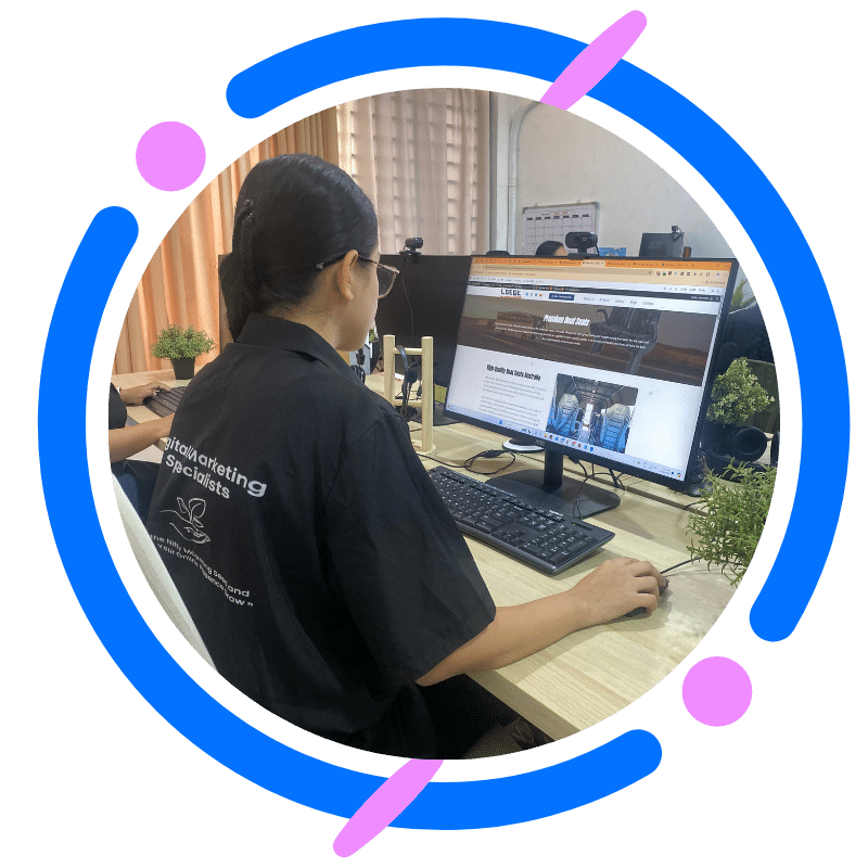 Woman working on website design at her computer in a modern office setting.