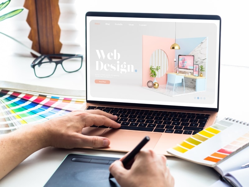 person creating website design white label mockup using stylus and color samples on a laptop